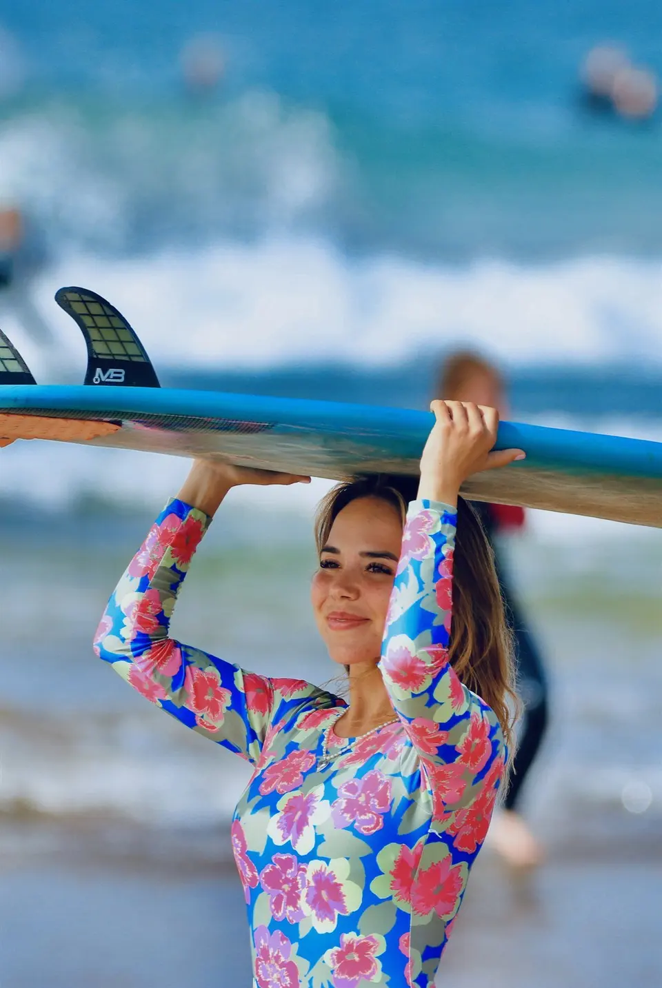 Surfer walking toward the ocean with a surfboard