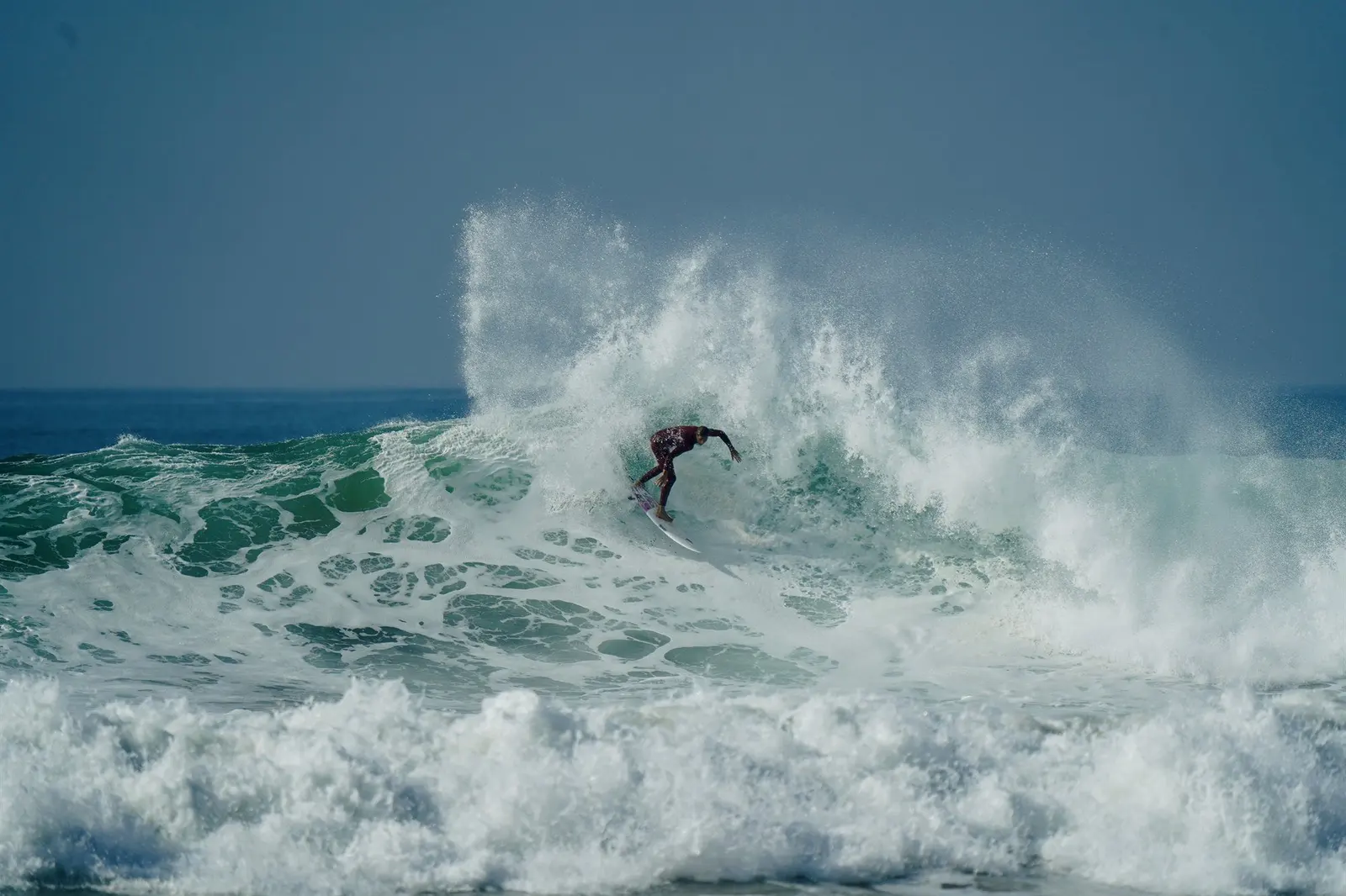 Solo surfer walking into the waves